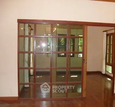 Spacious living room with elegant wooden sliding doors and polished hardwood floors.