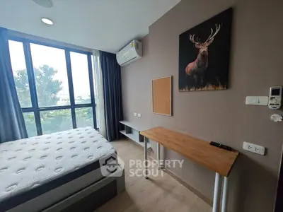 Modern bedroom with large windows and stylish decor in a bright apartment.