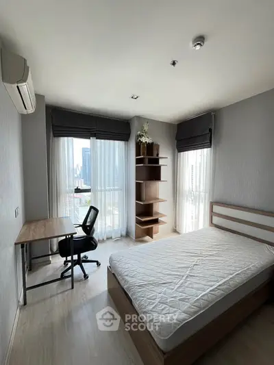 Modern bedroom with city view, featuring a study desk and sleek wooden furniture.