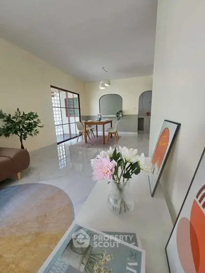 Spacious living room with modern decor and open dining area, perfect for family gatherings.