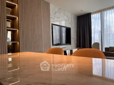 Luxurious modern living room with marble accents and large TV, perfect for relaxation and entertainment.