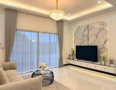 Luxurious living room with elegant chandelier and marble accent wall