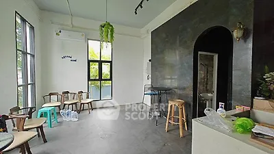 Spacious room with modern decor and large windows, ideal for versatile use.