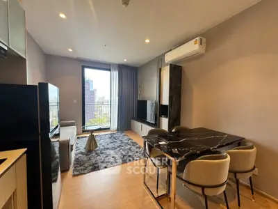 Modern living room with stylish furniture and balcony view in a high-rise apartment.