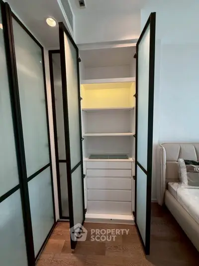 Modern bedroom with sleek storage unit and frosted glass doors
