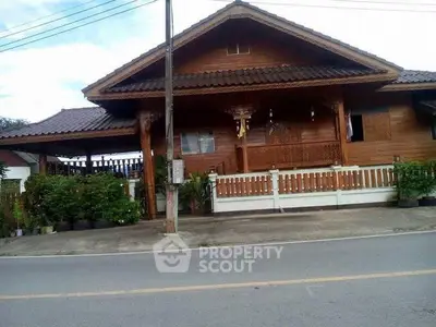 Charming traditional wooden house with lush greenery and inviting porch, perfect for serene living.