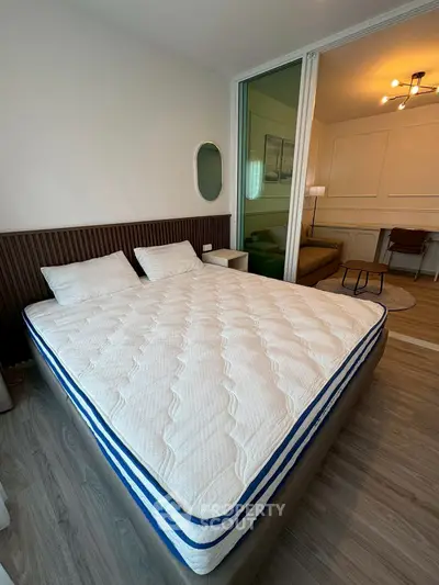 Modern bedroom with stylish decor and sliding glass doors leading to a cozy living area.