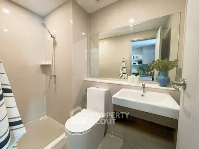 Modern bathroom with sleek fixtures and large mirror in a contemporary home.