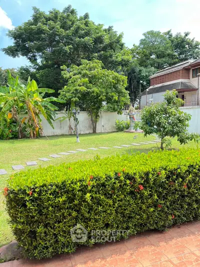 Lush green garden with manicured hedges and trees, perfect for outdoor relaxation.