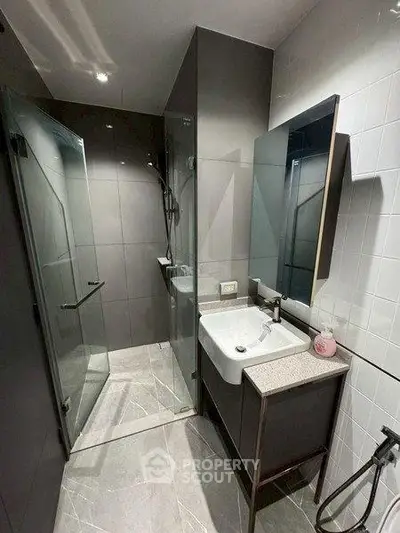 Modern bathroom with sleek design, featuring a glass shower and stylish vanity.