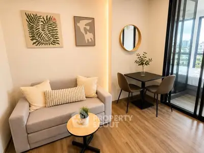 Modern living room with cozy sofa, stylish decor, and dining area in open layout apartment.
