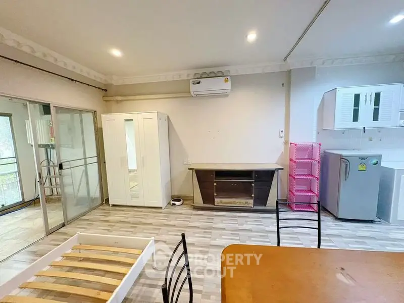 Spacious living area with modern furniture and balcony access in a bright apartment.