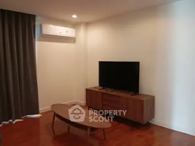 Modern living room with sleek wooden furniture and mounted TV, perfect for cozy relaxation.