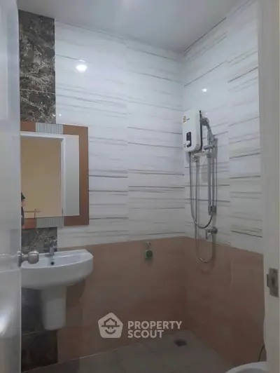Modern bathroom with sleek tiles and wall-mounted shower unit