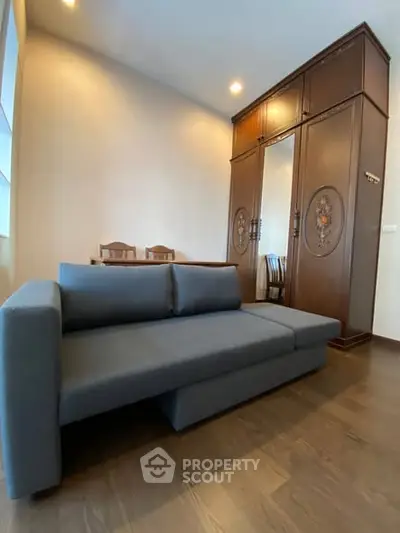 Spacious living room with modern sofa and elegant wooden wardrobe, perfect for stylish urban living.