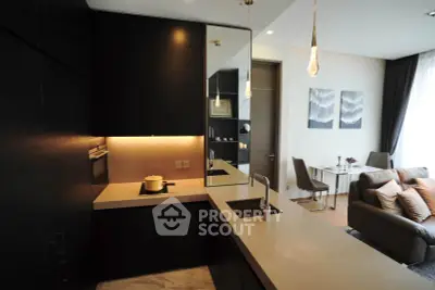Modern open-layout kitchen with sleek black cabinets and cozy living area