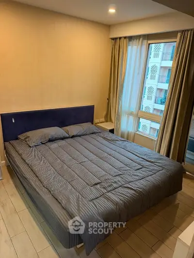 Modern bedroom with stylish decor and large window offering natural light