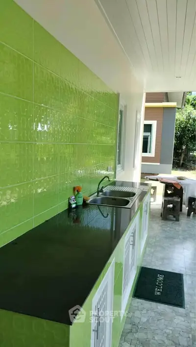 Modern outdoor kitchen with vibrant green tiles and sleek countertops
