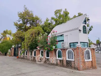 Charming small house with brick fence and lush greenery