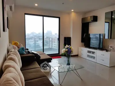 Modern living room with city view, stylish furniture, and large glass doors.