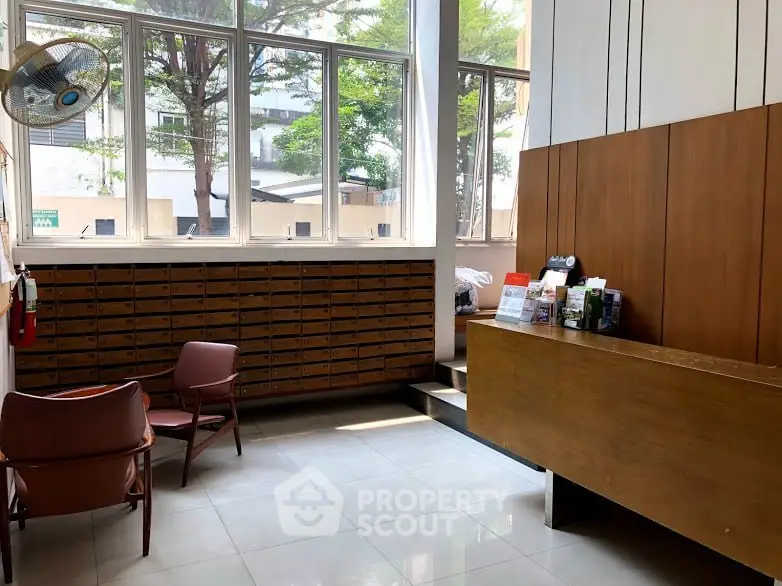 Spacious building lobby with mailboxes and seating area, perfect for welcoming guests.