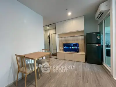 Modern living room with sleek furniture and built-in storage, featuring a flat-screen TV and dining area.