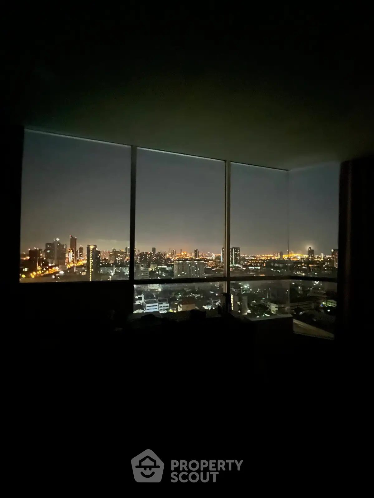 Stunning city skyline view from a high-rise apartment window at night.