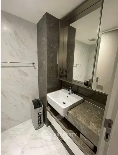 Modern bathroom with sleek marble design and stylish sink in luxury apartment.