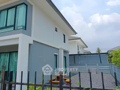 Modern two-story house with sleek design and spacious outdoor area.