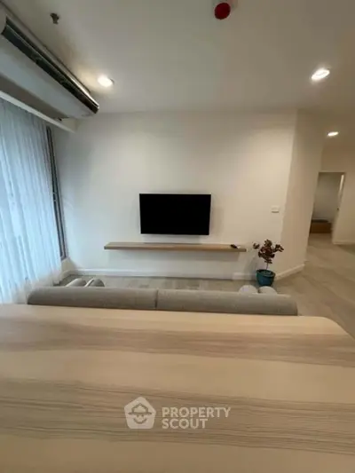 Modern living room with minimalist decor and wall-mounted TV