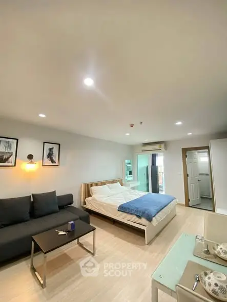 Spacious modern bedroom with cozy seating area and stylish decor