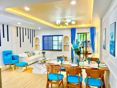 Stylish modern living and dining area with vibrant blue accents and elegant decor.
