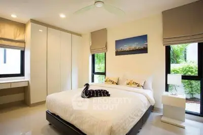 Modern bedroom with elegant decor, large windows, and stylish furnishings in a cozy setting.