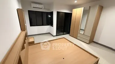 Spacious bedroom with modern wooden furniture and air conditioning