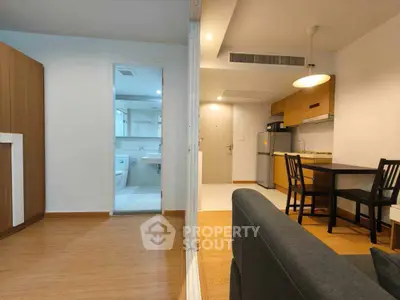 Modern apartment interior with open layout, featuring a cozy living area, dining space, and compact kitchen.