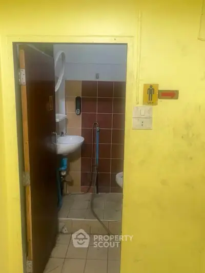 Men's restroom with sink and toilet in a tiled interior