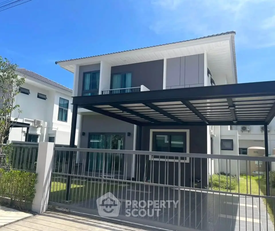 Modern two-story house with sleek design and spacious driveway in a sunny neighborhood.
