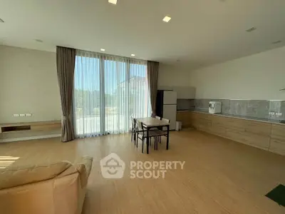 Spacious living room with open kitchen and large windows