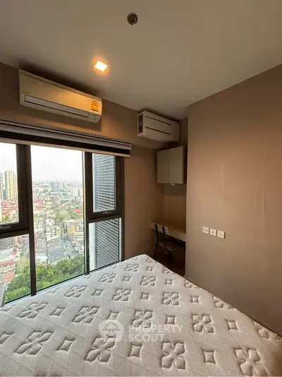 Modern bedroom with city view, featuring air conditioning and a cozy workspace.