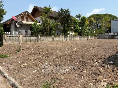 Prime residential land with potential for development, surrounded by lush greenery and neighboring homes.