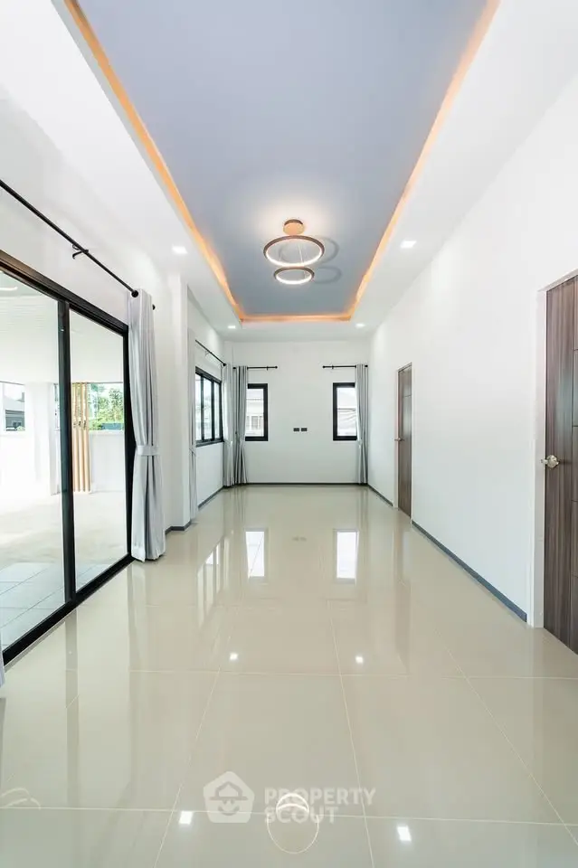 Spacious modern living room with elegant lighting and large windows for natural light.