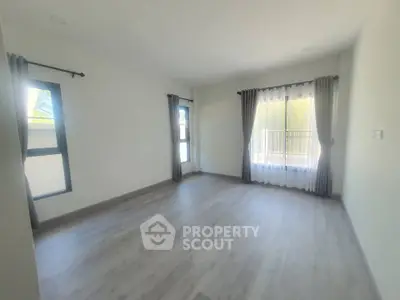 Spacious empty room with large windows and balcony access, perfect for customization.