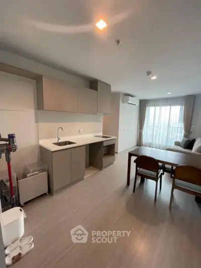 Modern open-layout kitchen and living area with sleek design and natural light.