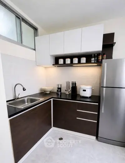 Modern kitchen with sleek cabinets and stainless steel appliances in a stylish apartment.