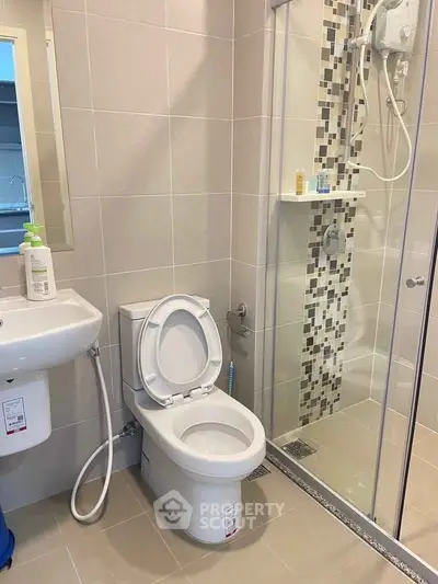 Modern bathroom with sleek shower and toilet in contemporary apartment.