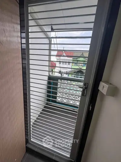 Charming balcony view with secure door and scenic neighborhood backdrop, perfect for relaxation and enjoying fresh air.