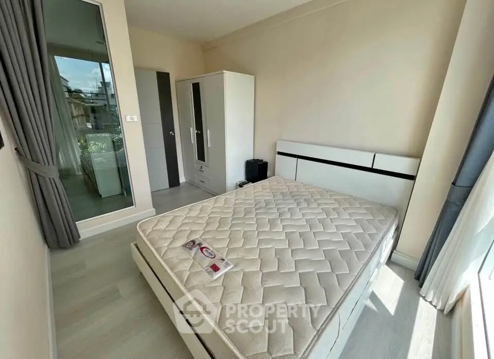 Bright bedroom with large window and modern furniture in a cozy apartment.