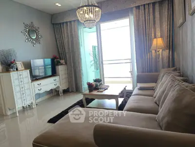 Luxurious living room with elegant chandelier and spacious balcony view.