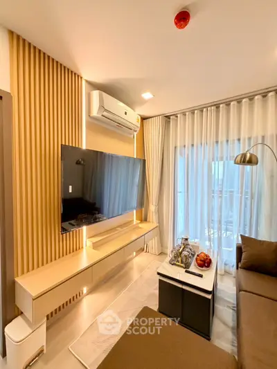 Modern living room with sleek design, featuring a wall-mounted TV, stylish furniture, and large windows for natural light.