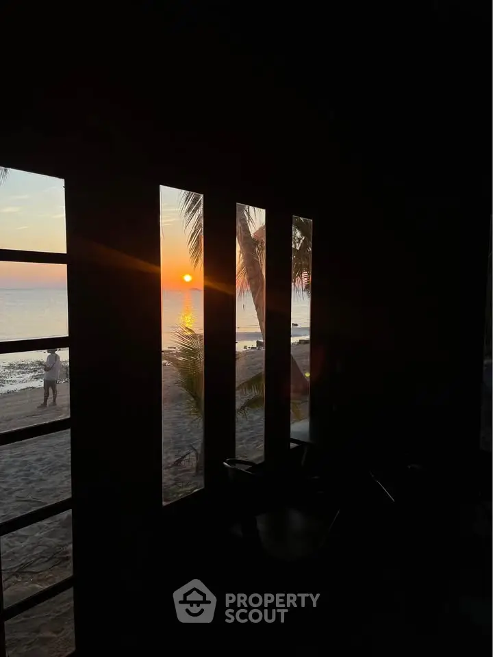 Stunning beachfront view from a cozy interior at sunset, perfect for relaxation and tranquility.